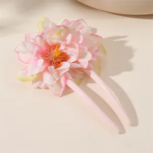 Primo piano del fermacapelli floreale rosa a forma di U, con dettagli di petali delicati.