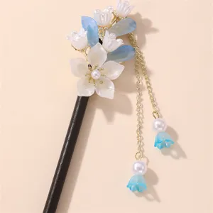 Exquisite floral hair stick detail showing delicate white petals, blue leaves and pearl tassel.