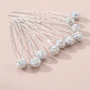 Close-up detail of silver U-shaped hairpins with colorful crystal rhinestone balls.