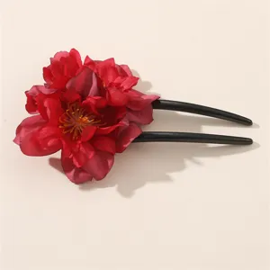 Vista dettagliata della forcina a U con fiori rossi, elegante accessorio per capelli tradizionale.