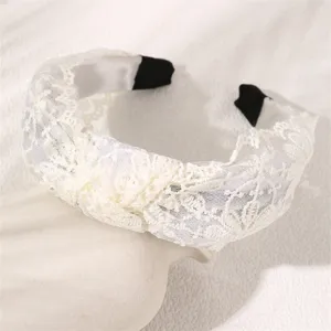 White lace headband detail display, showcasing delicate floral lace texture and elegant knot style.