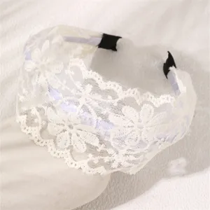 White lace headband detail close-up showing intricate floral embroidery and soft fabric texture.
