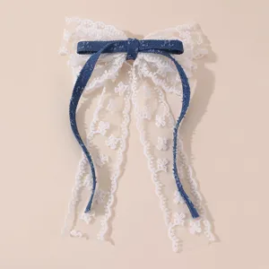Detailaufnahme der weißen Spitzen Schleifen Haarklammer mit blauem Jeans Band Akzent.