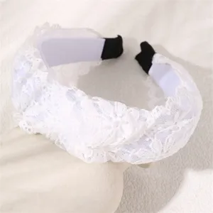 White lace headband detail, elegant wide hair hoop close-up, soft fashion accessory.