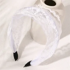 White lace headband detail showing delicate mesh fabric and elegant floral pattern design.