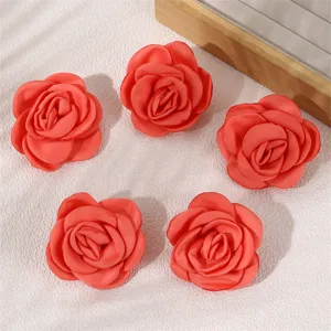 Detailed closeup of five red fabric rose hair clips, perfect for autumn and winter vibes.
