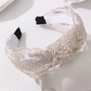 White lace knotted headband detail showing elegant floral embroidery and soft fabric texture.