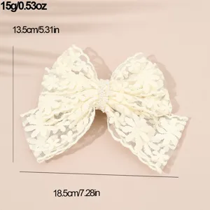 Details of the elegant white lace bow hair clip with pearl center, showing size and weight.