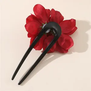 Primo piano dettagliato di una forcina per capelli a U nera con decorazione di fiori.