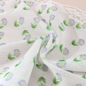 Detailed view of fresh floral hair accessory fabric with delicate white lace trim and purple flowers.