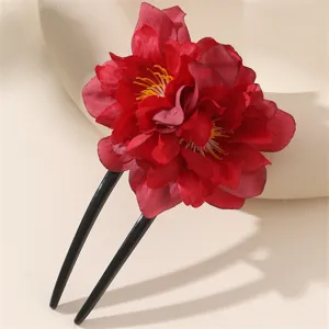 Primo piano di un forcina per capelli rossa a forma di U, con fiori di stoffa a strati e asta nera lucida.