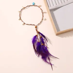 Détail de bandeau tressé en plumes bohème, avec coquillages naturels et plumes violettes.