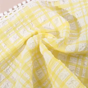 Close up detail of yellow white plaid fabric hair band with cute white lace pom pom trim.