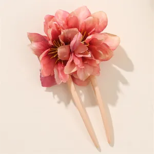 Primo piano dettagliato del grazioso fermaglio per capelli a forma di U con fiore in tessuto.