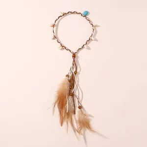Bandeau bohème en plumes avec coquillages et perles, idéal pour les festivals et voyages.