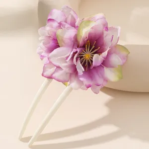 Primo piano di un dettaglio di forcina a U floreale rosa dolce, design minimalista.