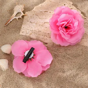 Gros plan détaillé d'une pince à cheveux fleur en tissu rose avec texture de dégradé.