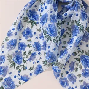 Chiffon blue floral hair accessory fabric detail, elegant floral pattern texture close-up.