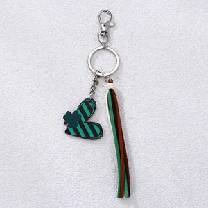 Detail shot of St. Patricks Day keychain featuring heart clover pendant and colorful tassel.