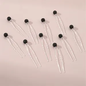 Detailed view of U-shaped hairpins with black rhinestone ball heads, elegant bun hair accessories.