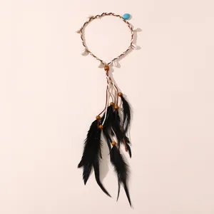 Détail de bandeau de plumes bohème avec corde tressée, coquillages et jolies plumes noires.