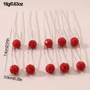 Detailed view of red rhinestone U-shaped hairpins showing sparkling crystal ball textures closely.