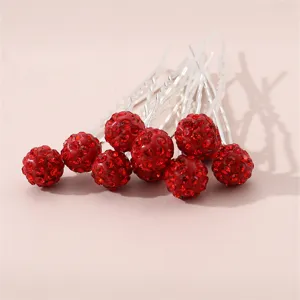 Detail shot of red rhinestone spherical U-shaped hair pins, sparkling crystal hair accessory.