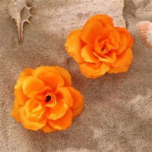 Gros plan détail pinces cheveux tissu orange vif pour un style doux et charmant au quotidien.