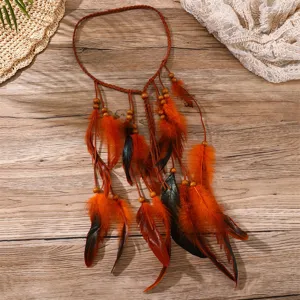 Détail du bandeau à plumes style bohème avec corde tressée, perles en bois et plumes orange.
