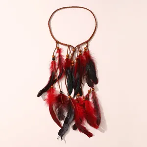 Gros plan détaillé du bandeau de plumes bohème avec perles en bois et plumes rouges.