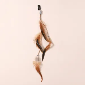 Gros plan détaillé de pince à cheveux plume bohème avec belles plumes brunes et perles.