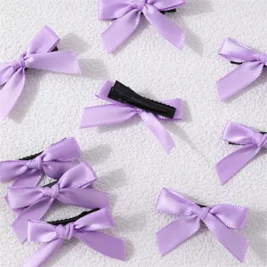 Close-up detail view of light purple ribbon hair bows with black clips, sweet style.