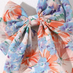 Detail view of a sweet floral fabric hair bow, elegant design with vibrant colors.