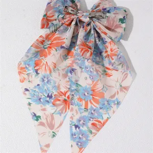 Detailed view of the floral fabric hair bow spring clip, showcasing colorful prints and metal clasp.