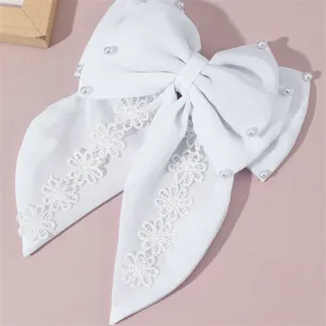 White fabric hair bow detail, elegant lace floral trim and pearl accents, long ribbon style.