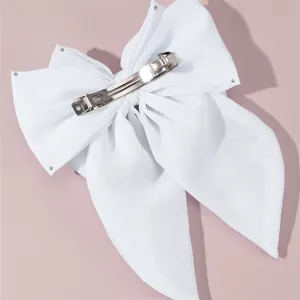 White fabric bow hair clip detail, elegant bridal barrette back view with metal clasp, soft ribbon.