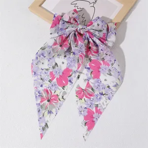 Detailed close-up of the floral fabric long streamer bow hair clip showing exquisite pattern.