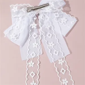 White lace hair bow detail showing delicate floral embroidery and metal clip for bridal wear