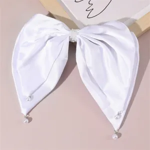 White satin hair bow clip detailed with delicate pearls and charming hanging drops.