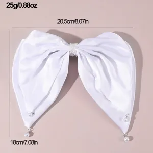 Detailed view of the elegant white satin bow hair clip featuring delicate pearl pendants.