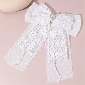 White lace bow hair clip for bridal wedding, elegant fabric hair accessory with long pearl streamers.