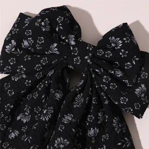 Close-up detail of black floral fabric hair bow, elegant vintage sweet style hair clip