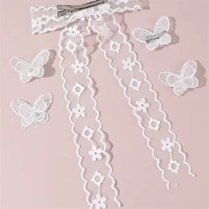Detailed view of white lace bow hair clip and matching butterfly clips for bridal and party wear.
