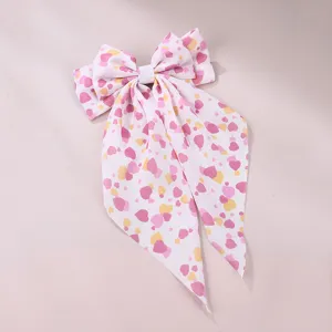 Sweet fabric hair clip detail showing pink heart print bow and long streamer ribbon.