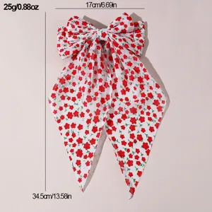Detailed view of sweet floral fabric hair bow with long ribbons and metal spring clip.