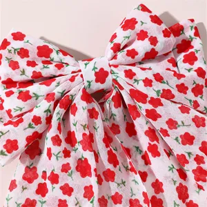 Close-up detail of the red floral print fabric bow hair clip with long ribbons design.