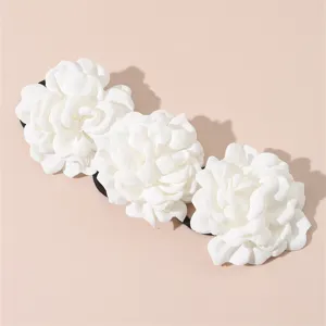 White fabric camellia flower hair tie detail shot, elegant bridal wedding hair accessory.