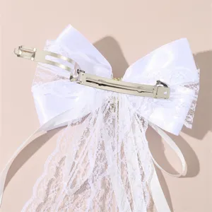 White lace bow hair clip bridal wedding hair accessory with long ribbon back detail.