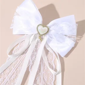 White lace bow hair clip close-up detail, elegant bridal hair accessory for wedding styling.