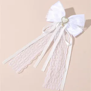 White lace ribbon hair bow detail showing delicate fabric, lace trim and pearl heart charm.